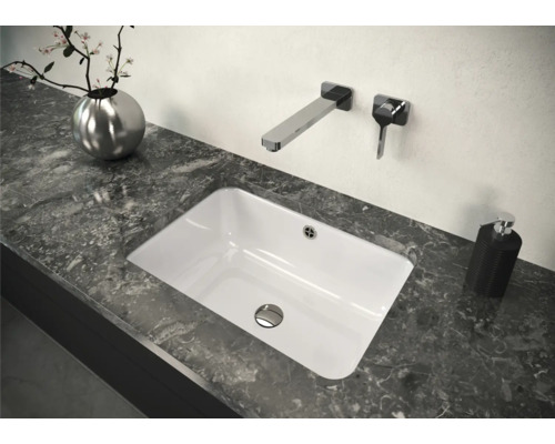 Eingebautes Waschbecken im Badezimmer mit Armatur und Dekor