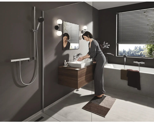 Badezimmer mit Dusche, Waschbecken, Badewanne und Frau beim Händewaschen