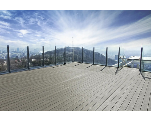 Terrasse avec planches en bois et garde-corps en verre donnant sur la ville