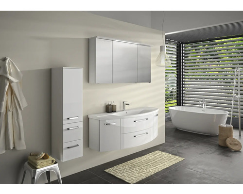 Salle de bain lumineuse avec baignoire, meuble-lavabo, armoire de toilette et armoire haute