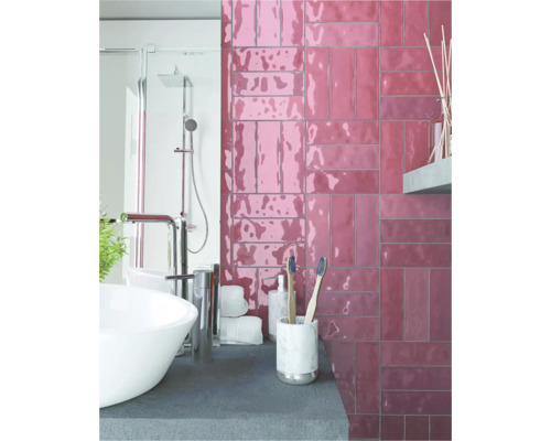 Badezimmer mit Waschbecken, Dusche und Wandfliesen in Ziegeloptik