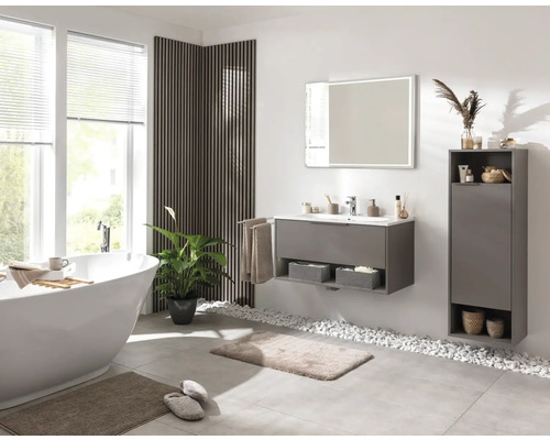 Salle de bains lumineuse avec baignoire, meuble-lavabo, miroir et éléments de rangement pour une ambiance moderne