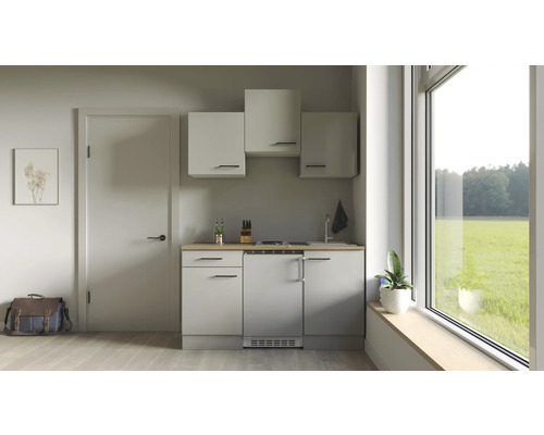 Petite cuisine avec éléments hauts, évier, plaque de cuisson et réfrigérateur dans une pièce lumineuse