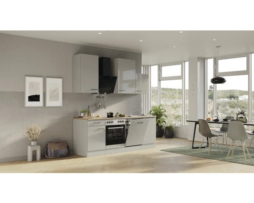 Heller Wohnraum mit Küchenzeile, Esstisch und Stühlen.