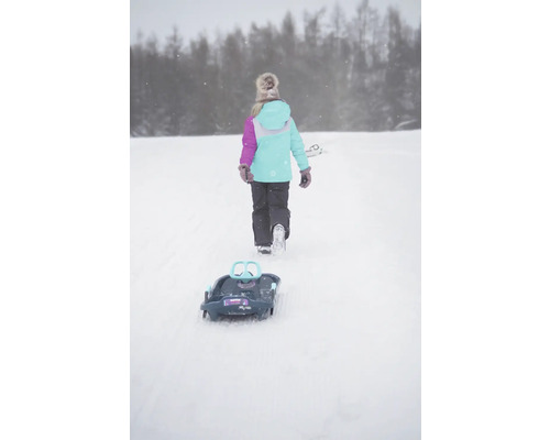 Une fille tire une luge dans la neige.