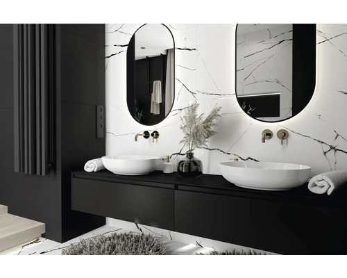 Salle de bains moderne avec deux lavabos, meubles bas noirs, miroirs ovales et carrelage en marbre