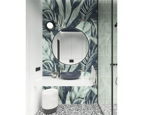 Salle de bain moderne avec miroir rond, meuble-lavabo, vasque à poser et motif de feuilles tropicales sur le mur.
