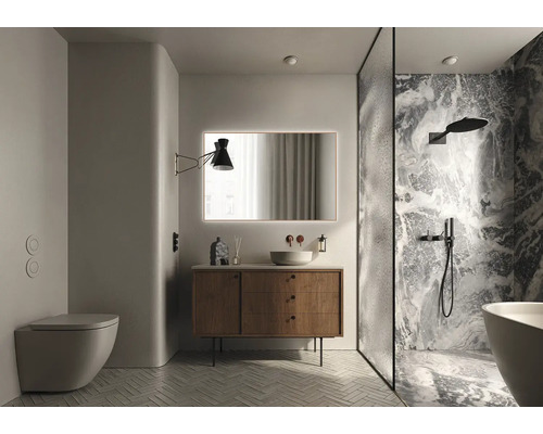 Salle de bain lumineuse avec toilettes, lavabo avec miroir, lampe et douche