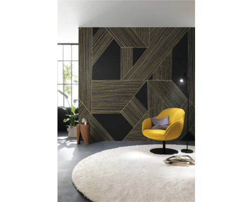 Wohnzimmer mit gemusterter Wandverkleidung, gelbem Sessel und rundem Teppich