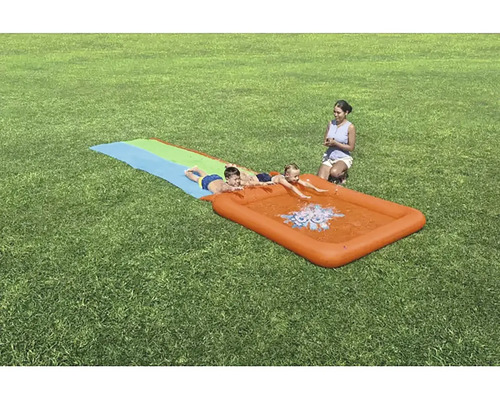 Toboggan aquatique avec trois enfants sur une pelouse avec un superviseur