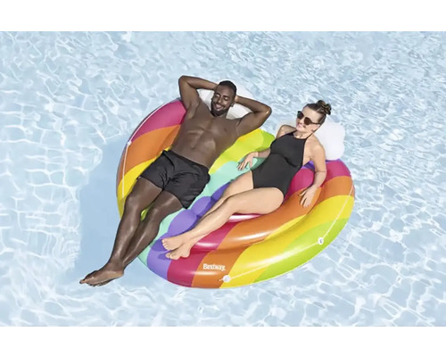 Zwei Personen entspannen auf einer bunten, aufblasbaren Poolinsel im Wasser.