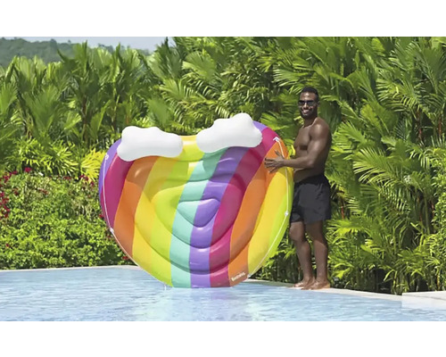 Aufblasbare herzförmige Poolinsel mit Regenbogenfarben und Wolkenapplikationen neben einem Pool