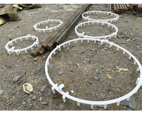 Plusieurs entretoises en plastique pour cages d''armatures sur un chantier