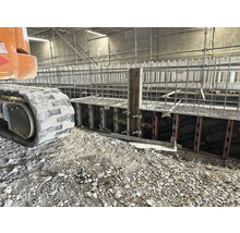 Baustelle mit Schalung, Armierung und Raupenbagger