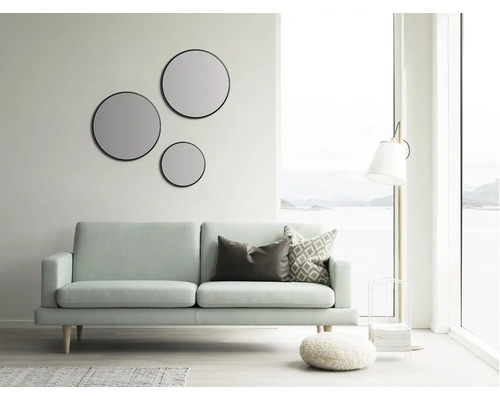 Helles Wohnzimmer mit Sofa, runden Spiegeln und Stehlampe