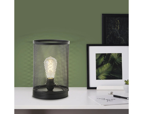 Lampe de table en grillage métallique avec ampoule sur une table
