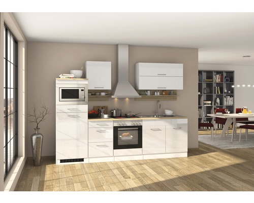 Cuisine moderne avec armoires blanches, hotte aspirante et appareils électriques.
