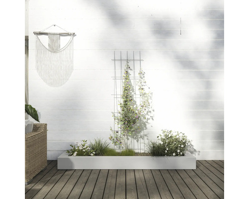 Szene mit einem Pflanzkasten, einer Rankhilfe und einer Wanddekoration im Aussenbereich.