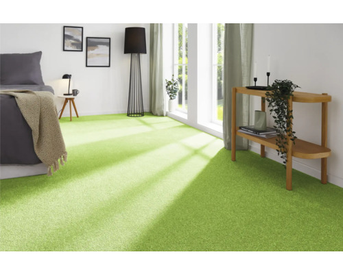 Chambre moderne avec moquette verte, lit, lampe et décoration