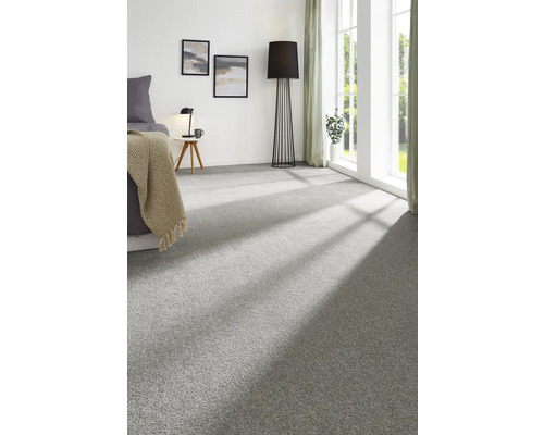 Moquette grise dans une chambre avec lit, lampadaire et fenêtre.