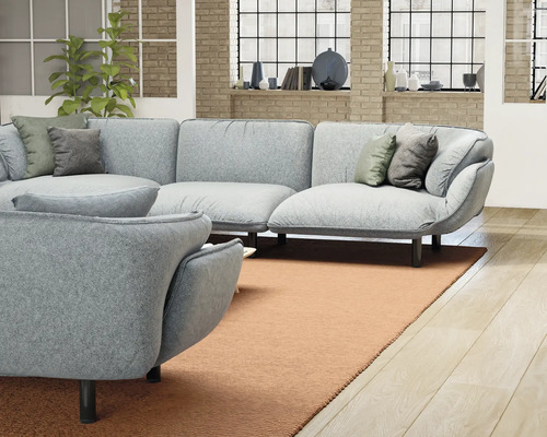 Wohnzimmer mit grauer Eckcouch, Sessel und Teppich