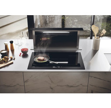 Cuisine avec plaque de cuisson, hotte et aliments sur le plan de travail