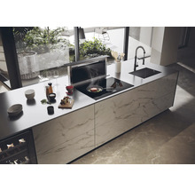Cuisine moderne avec îlot de cuisine, hotte aspirante, évier et plaque à induction.