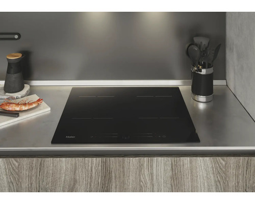 Plaque à induction Haier noire dans une cuisine moderne.
