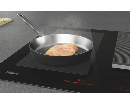 Filet de poisson dans une poêle sur une plaque à induction Haier.
