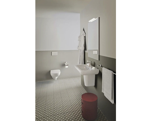 Salle de bain lumineuse avec toilettes, lavabo, miroir et tabouret rouge
