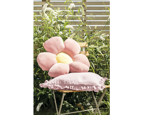 Scène de jardin avec une chaise ornée d''un coussin en forme de fleur et d''un coussin rectangulaire