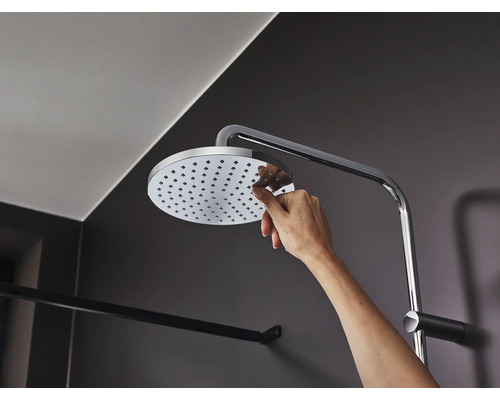 Hand berührt Duschkopf mit Brausearm im Badezimmer