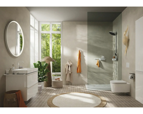 Badezimmer mit Waschtisch, Spiegel, Toilette und Dusche.