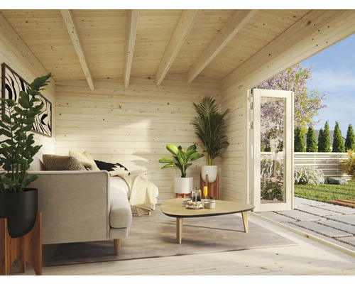 Helle Holzhütte mit Sofa, Tisch und Pflanzen im Innenraum und geöffneter Tür zum Garten