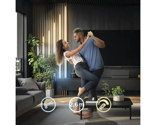 Couple dansant dans le salon devant un téléviseur