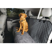 Chien assis sur une housse de siège de voiture avec motif losanges et texture de tapis