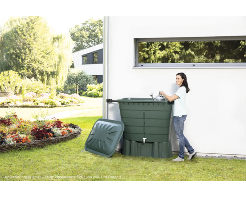 Vue de jardin avec récupérateur d''eau, femme et arrosoir.