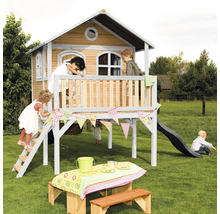 Spielhaus mit Rutsche, Leiter und Picknicktisch im Garten mit spielenden Kindern