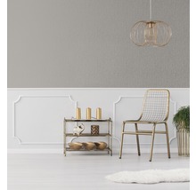 Dekorativer Raum mit grauer Tapete, goldener Lampe, Stuhl und Regal
