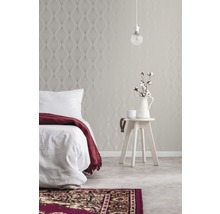 Chambre avec papier peint à motifs, lit, table d''appoint et tapis
