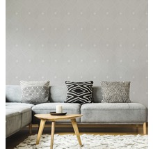 Wohnzimmer mit grauer Couch, Kissen und Tapete mit geometrischem Muster