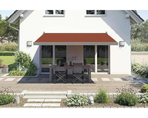 Hausfassade mit Markise über Terrassentisch und Stühlen