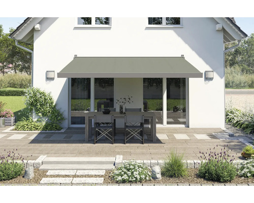 Hausfassade mit Markise über einer Terrassengarnitur