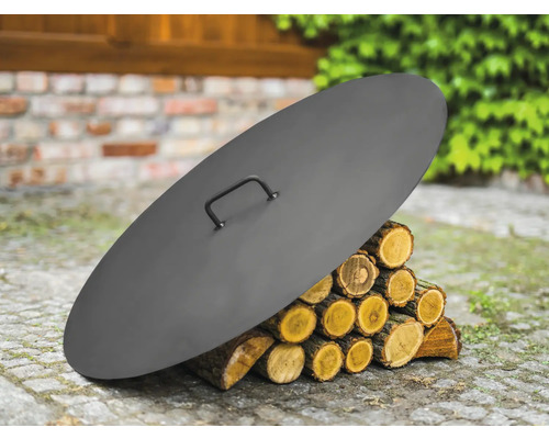 Couvercle en acier pour foyer sur une pile de bois