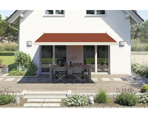 Hausfassade mit Markise über einer Terrassengarnitur