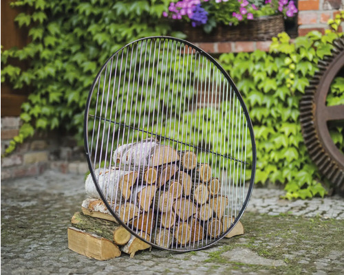 Grille de barbecue ronde en métal sur une pile de bois