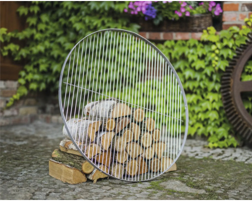 Grille de barbecue ronde en métal sur une pile de bois