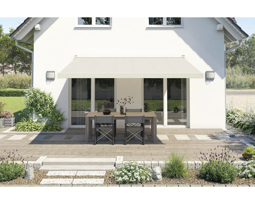 Hausfassade mit Markise über einer Terrassentischgruppe