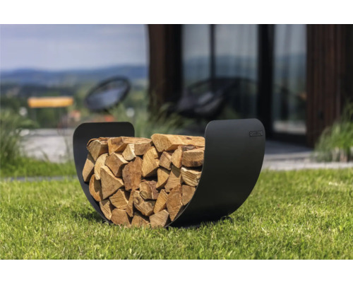 Holzlege aus Metall gefüllt mit Brennholz im Garten