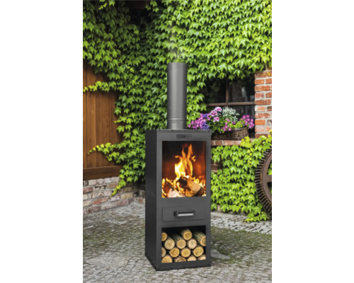 Cheminée d''extérieur avec bois dans le foyer et stockage du bois dans le jardin